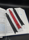 Trois marques page en cuir en noir ou rouge déposé sur une Bible 