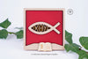 Cadre chrétien Ichthus symbole poisson en hêtre massif - Artisanat français avec versets bibliques NFC. Le cadre est présenté débout entre des lierres
