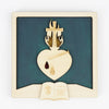 Tableau secret - Sacré cœur symbole des apparitions de Marguerite-Marie Alacoque à Paray le Monial. Le cadre a un fond vert émeraude, il est de face. Le cœur est traversé par un clou. Le cœur porte deux gouttes : une goutte de sueur gravée et une goutte de sang, peinte en rouge. Le feu qui entoure la croix positionnée sur le cœur est entouré de flammes dorées
