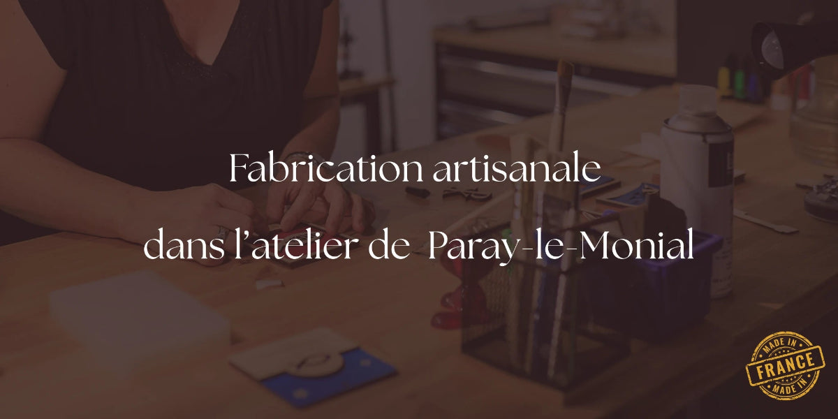 Photo d'un atelier avec des pinceaux et le tableau secret Ichthus en cours d'élaboration. Avec au centre la phrase qui dit "Fabrication artisanale dans l'atelier de Paray-le-Monial". Et le logo en bas à droite "Made in France"