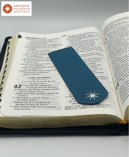 Signet bleu réalisé par les Moines de Bethléem. Le signet est bleu porte l'étoile des Moines de Bethléem. Il est posé sur une bible ouverte au Psaume 42
