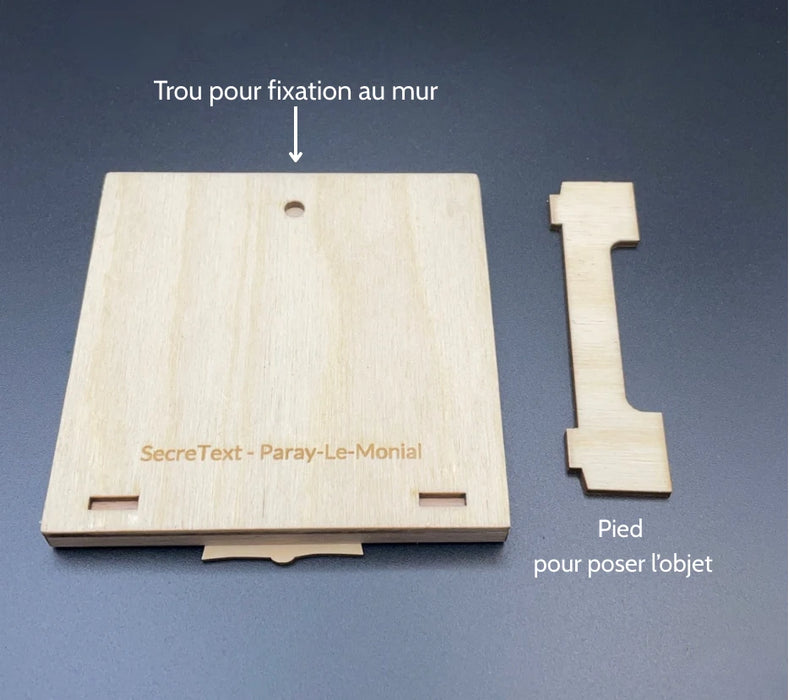 Arrière du tableau secret avec explication du fonctionnement de l'accroche. Trou pour une fixation au mur et pied pour poser l'objet.