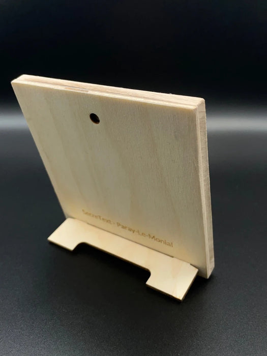 Dos du tableau secret en bois avec support pour en permettre le maintien debout. Un trou sur le haut du cadre permettant son accroche à un mur. En bas il est écrit SecreText avec le lieu de fabrication Paray le Monial.