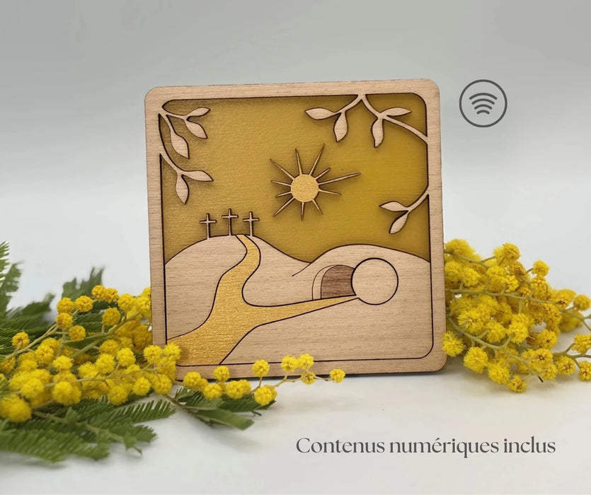 Cadre décoration religieuse chrétienne pour Pâques représentant les trois croix et le tombeau du Christ. La décoration est mise en valeur avec des branches de mimosas