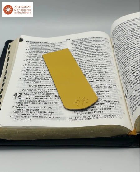 Signet jaune réalisé par les Moines de Bethléem. Le signet est jaune porte l'étoile des Moines de Bethléem. Il est posé sur une bible ouverte au Psaume 42